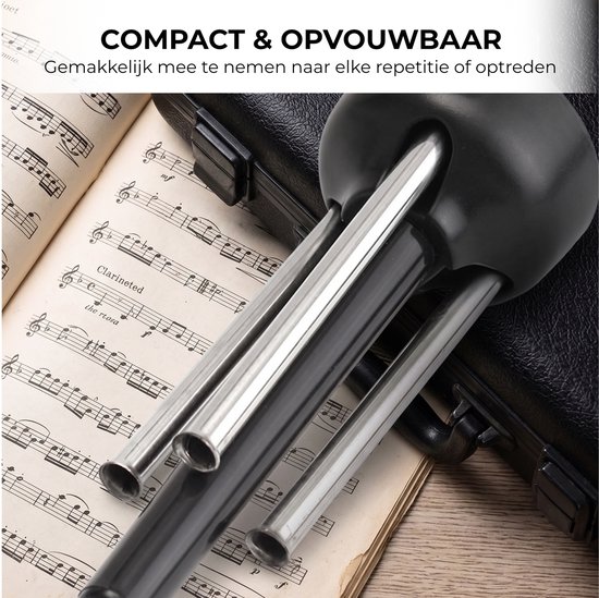 Zwarte houder met zilveren poten op muziekbladen. Compact en opvouwbaar.