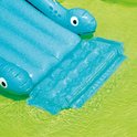 Detail van de blauwe dinosaurusglijbaan met een opblaasbare mat onderaan in het zwembad.