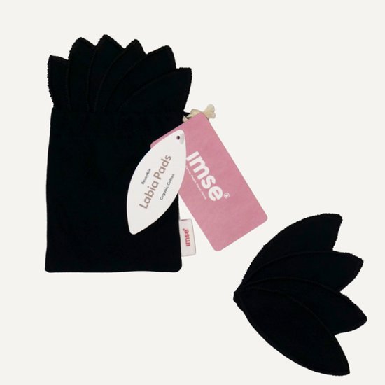 Zwarte labiapads, waarvan een deel in een bewaarzakje zit. Twee losse blaadjesvormige pads met een label.