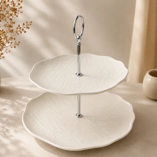 Étagère en céramique blanche à deux niveaux avec bords ondulés et poignée argentée.