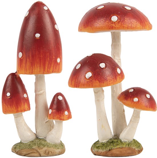 Cinq champignons rouges à pois blancs sur un lit vert.