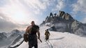 Kratos en Atreus lopen over een besneeuwde berg, met een grote rotsformatie op de achtergrond.