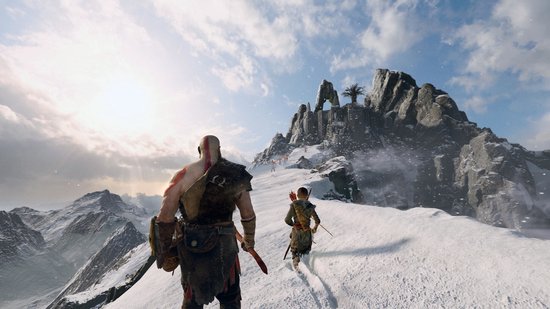 Kratos en Atreus lopen over een besneeuwde berg, met een grote rotsformatie op de achtergrond.