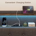 Station de recharge sur la tête de lit d'un lit rembourré, avec smartphone et tablette, plus ports USB.