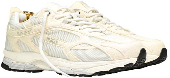 Crème Mercer sneaker, voorzijde. Mesh panelen, "MERCER" logo op de zijkant, witte veters. Zwarte neus.