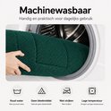 Donkergroene badmat wordt in een wasmachine geplaatst. Machine wasbaar op lage temperatuur, geen bleekmiddel.
