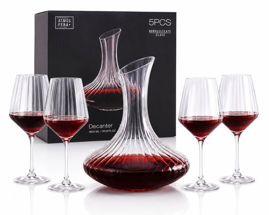 Une carafe à décanter en verre et quatre verres à vin, remplis de vin rouge, avec l'emballage noir de 5 pièces en verre borosilicaté en arrière-plan.
