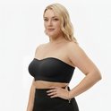 Model met blote schouders draagt een zwarte strapless push-up bh met uitneembare pads.
