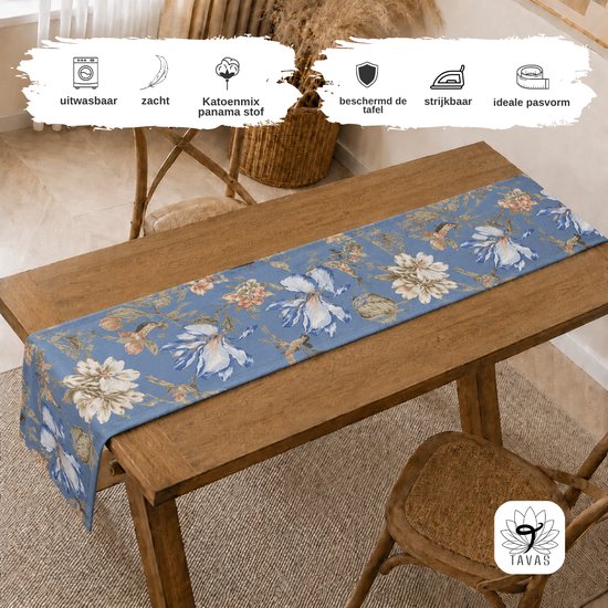 Blauwe tafelloper met bloemenprint en vogels, op een houten tafel.