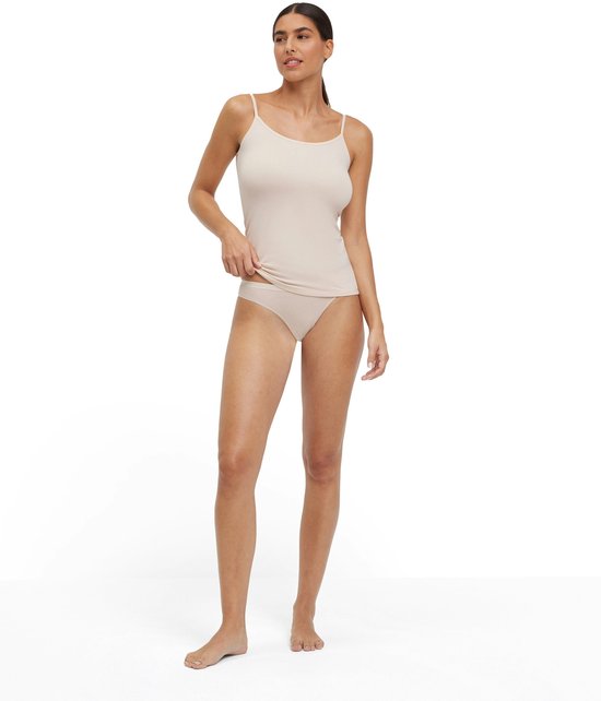 Model draagt een lichtbeige hemdtop en bijpassende slip.