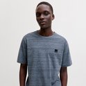 Donkerblauwe, gemêleerde T-shirt met korte mouwen met een zwart logo-label op de borst, gedragen door een man.