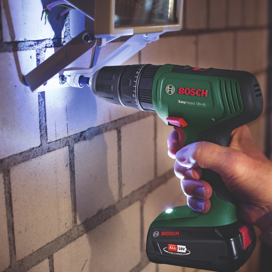 Bosch EasyImpact 18V-40 boort in een stenen muur, verlichting schijnt op het werkgebied.