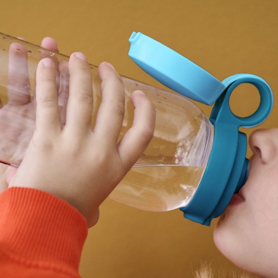 Kind drinkt uit een transparante Mepal drinkfles met blauwe dop.