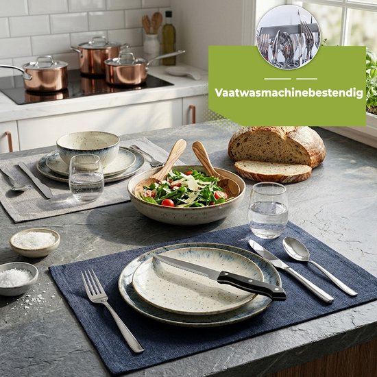 Zilveren bestek op een donkerblauwe placemat, naast een bord met een salade en een kom soep. "Vaatwasmachinebestendig" wordt getoond.