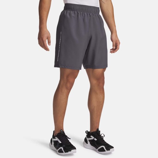 Man in donkergrijze sportbroek met 'UNDER ARMOUR' logo op de zijkant.