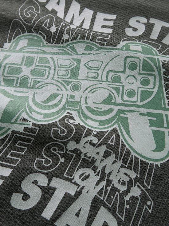 Close-up van de print op een donkergrijze sweater met een groene videogamecontroller en tekst.