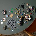 Overzicht van LEGO-onderdelen en een blauwe LEGO-trein met wielen, sporen, miniatuurfiguren en kerstdecoraties.