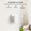 Witte Reolink deurbelplug met blauwe ring in een stopcontact, toont volume en beltonen.