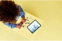 Kind bouwt rode raceauto met Spiderman-figuur en tablet met instructies.