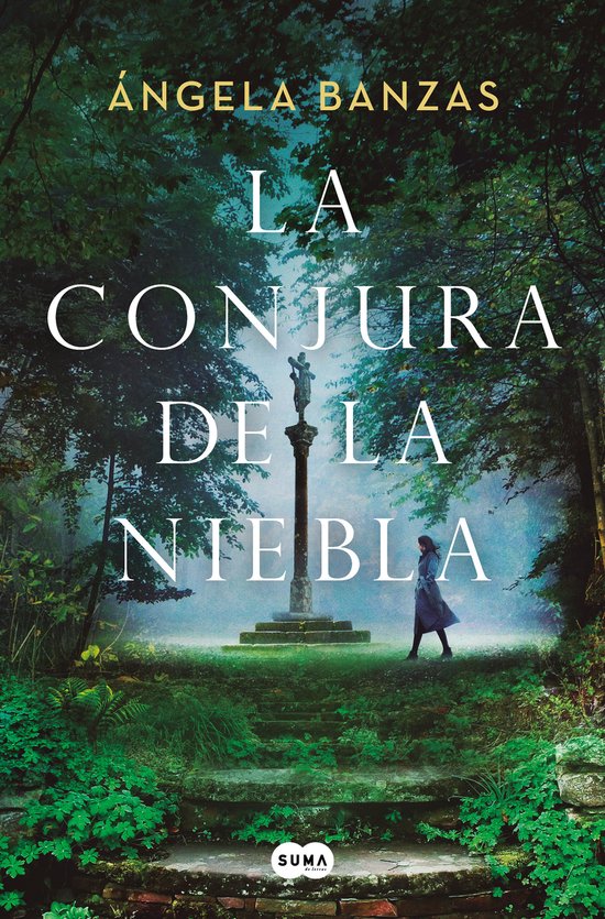 Boekomslag van 'La Conjura de la Niebla' met een vrouw in een blauwe jas die op een mistig stenen pad in een bos staat, met een beeld op een pilaar in het midden.