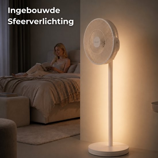 Witte staande ventilator met sfeerverlichting op de vloer in een slaapkamer, een vrouw leest op bed.