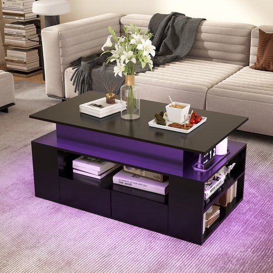 Zwarte salontafel met lift-bureau en paarse LED-verlichting, met vaas, boek en snacks.