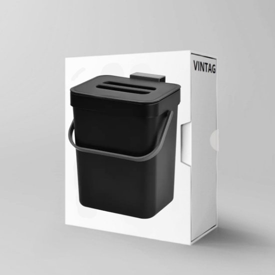 Zwarte compostbak met deksel en handvat, in verpakking.
