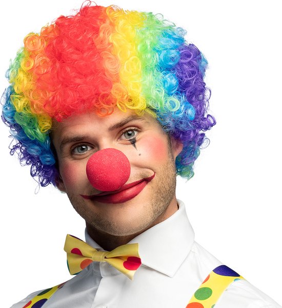 Een man met een regenboogkleurige krulpruik, clownsmake-up, een rode neus en een gestippelde vlinderdas.