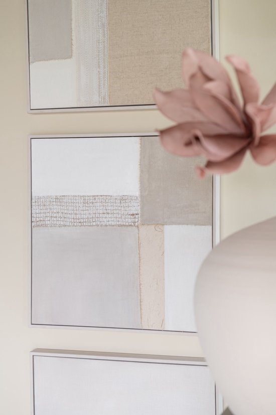 Détail de peintures abstraites beiges, blanc cassé et grises, avec une fleur rose et un vase au premier plan.