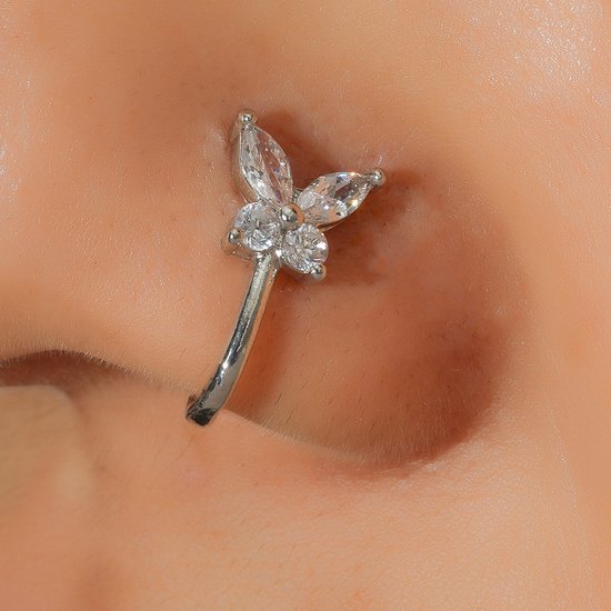 Zilverkleurige neuspiercing met vlindervormige kristallen, gedragen op de neus.
