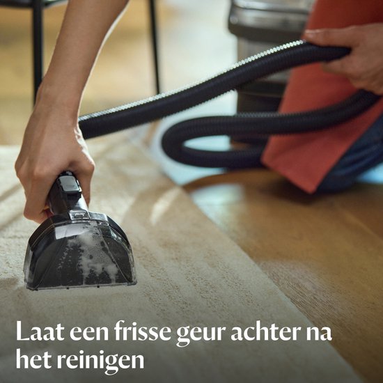 Detail van de reinigingskop van een BISSELL SpotClean apparaat dat een tapijt reinigt.