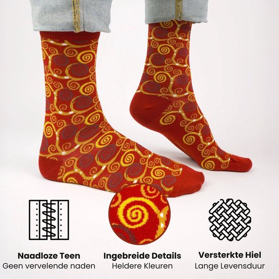 Een paar rode sokken met een gouden en bruine spiraalprint, gedragen door een persoon.