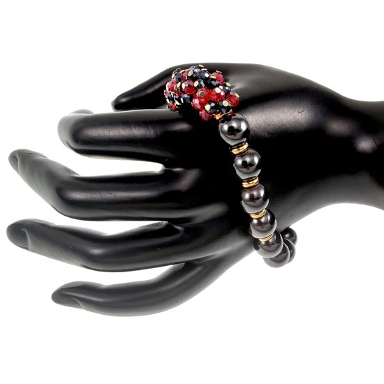 Zwarte kunsthand met een armband van donkere, glanzende kralen, gouden accenten en rode, blauwe en zwarte kristallen.
