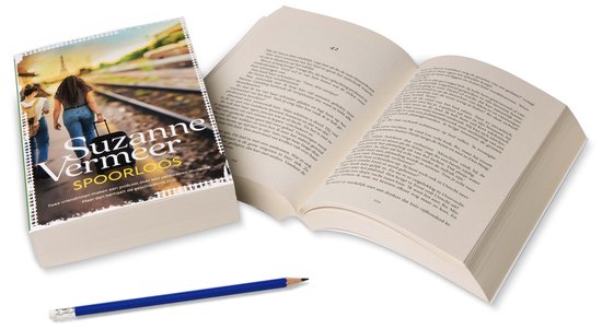 Boek Spoorloos van Suzanne Vermeer, naast een openliggend boek en een potlood. De kaft toont twee meisjes op een treinstation.