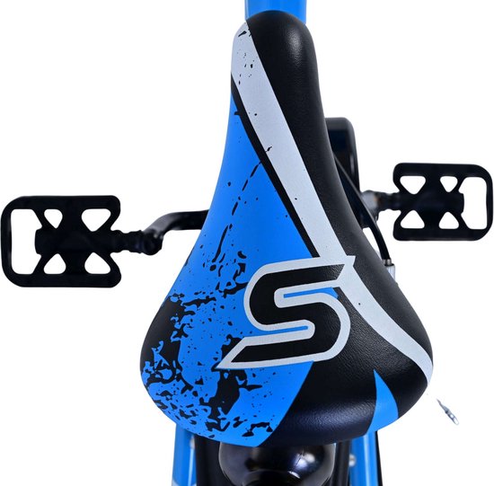 Zadel van een kinderfiets met blauw, zwart en wit spettermotief en een groot 'S' logo.