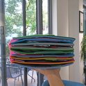 Hand die een dik, veelkleurig educatief activiteitenboek van vilt vasthoudt.