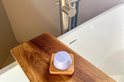 Paarse RTHINK conditioner bar op een houten dienblad in een badkuip.