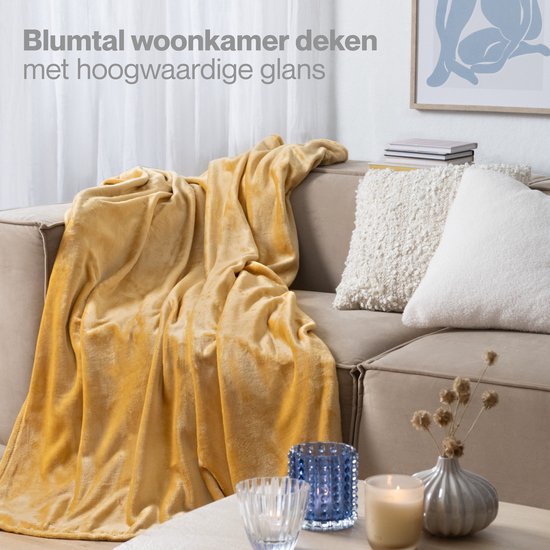 Gele plaid op een bank in een woonkamer.