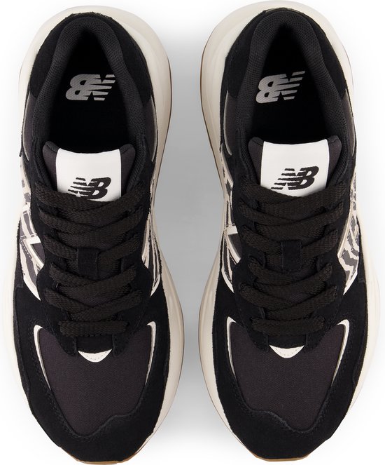 Bovenkant van zwarte New Balance sneakers met zebraprint, witte veters en New Balance logo's.