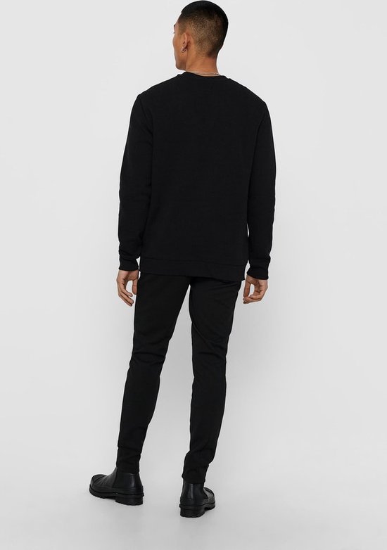 Man met zwarte sweater, van achteren gezien.