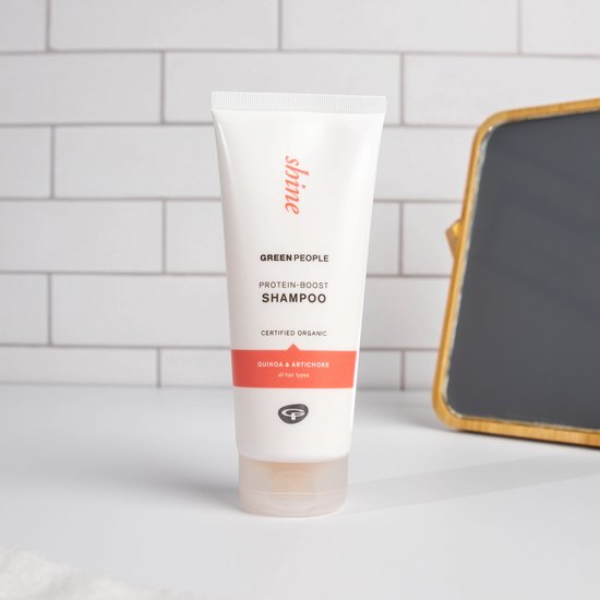 Green People Protein-Boost Shampoo, quinoa & artisjok, gecertificeerd biologisch, in een witte tube met oranje band.