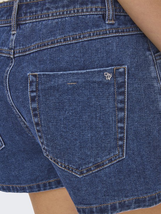 Donkerblauwe denim rok met een opgestikte zak en een metalen logo op de achterkant.