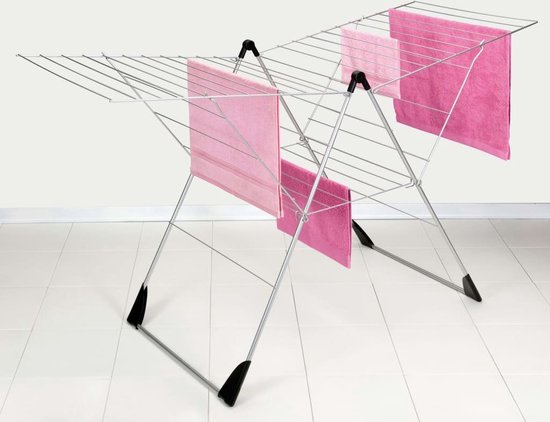 Zilvergrijs droogrek met vier roze handdoeken.