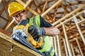 Een bouwmedewerker snijdt een plank met een DeWalt decoupeerzaag.