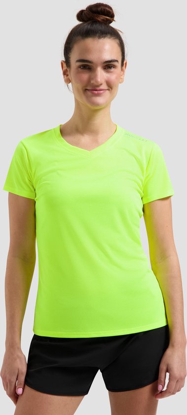 Model in een fluo geel sportshirt met korte mouwen en V-hals, lachend naar de camera.