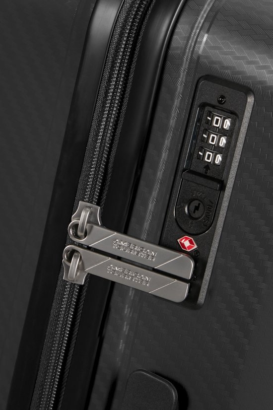 Close-up van de zwarte koffer met TSA-combinatieslot en dubbele ritssluitingen.