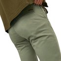Achterkant lichtgroene chino met bruine label.