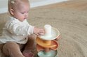 Baby speelt met een meerkleurige spiraaltoren met ballen.