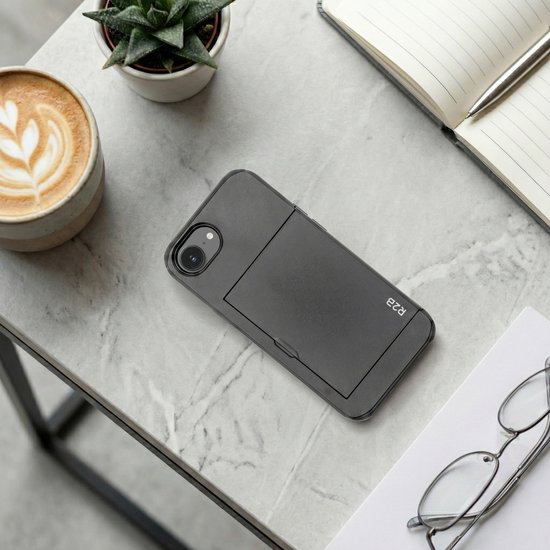 Coque de téléphone R2B noire avec porte-cartes sur une table en marbre à côté d'une tasse de café.