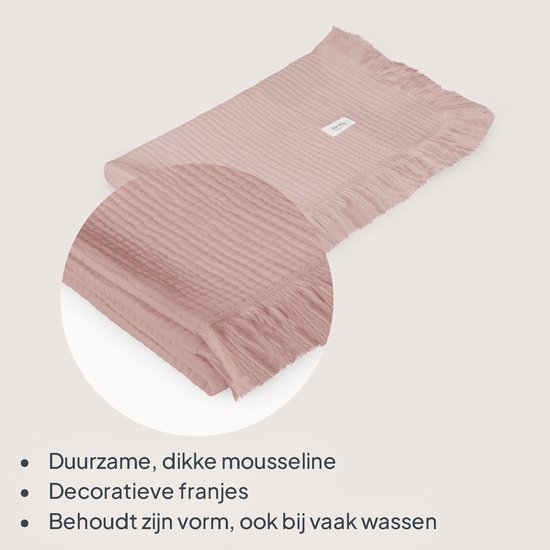 Lichtroze mousseline deken met geribbelde textuur en decoratieve franjes.